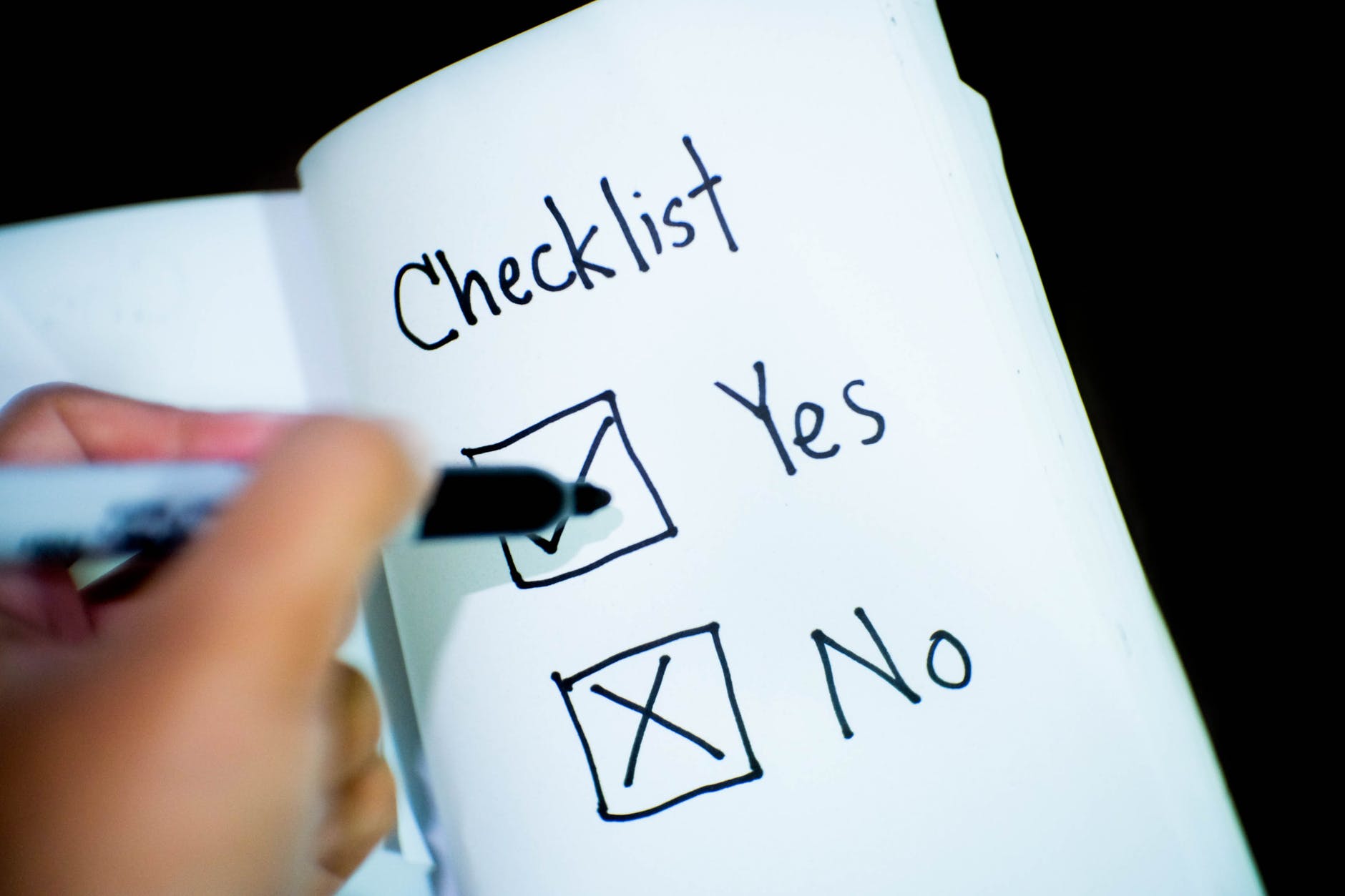 Person ticking off a yes or no checklist